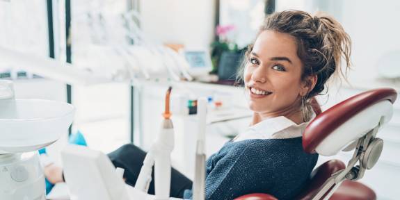 Frau auf rotem Zahnarztstuhl